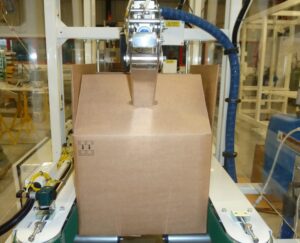Automated machinery handling a cardboard box