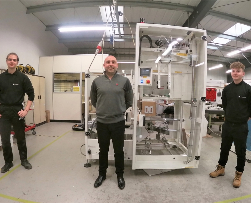 Men standing near a machine.