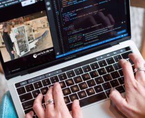 Hands typing on a laptop keyboard.